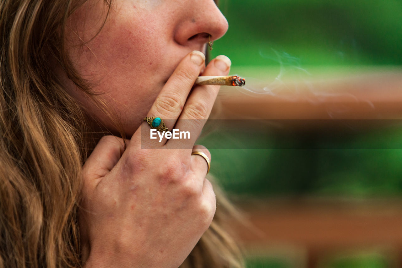 Close-up of woman smoking weed outdoors