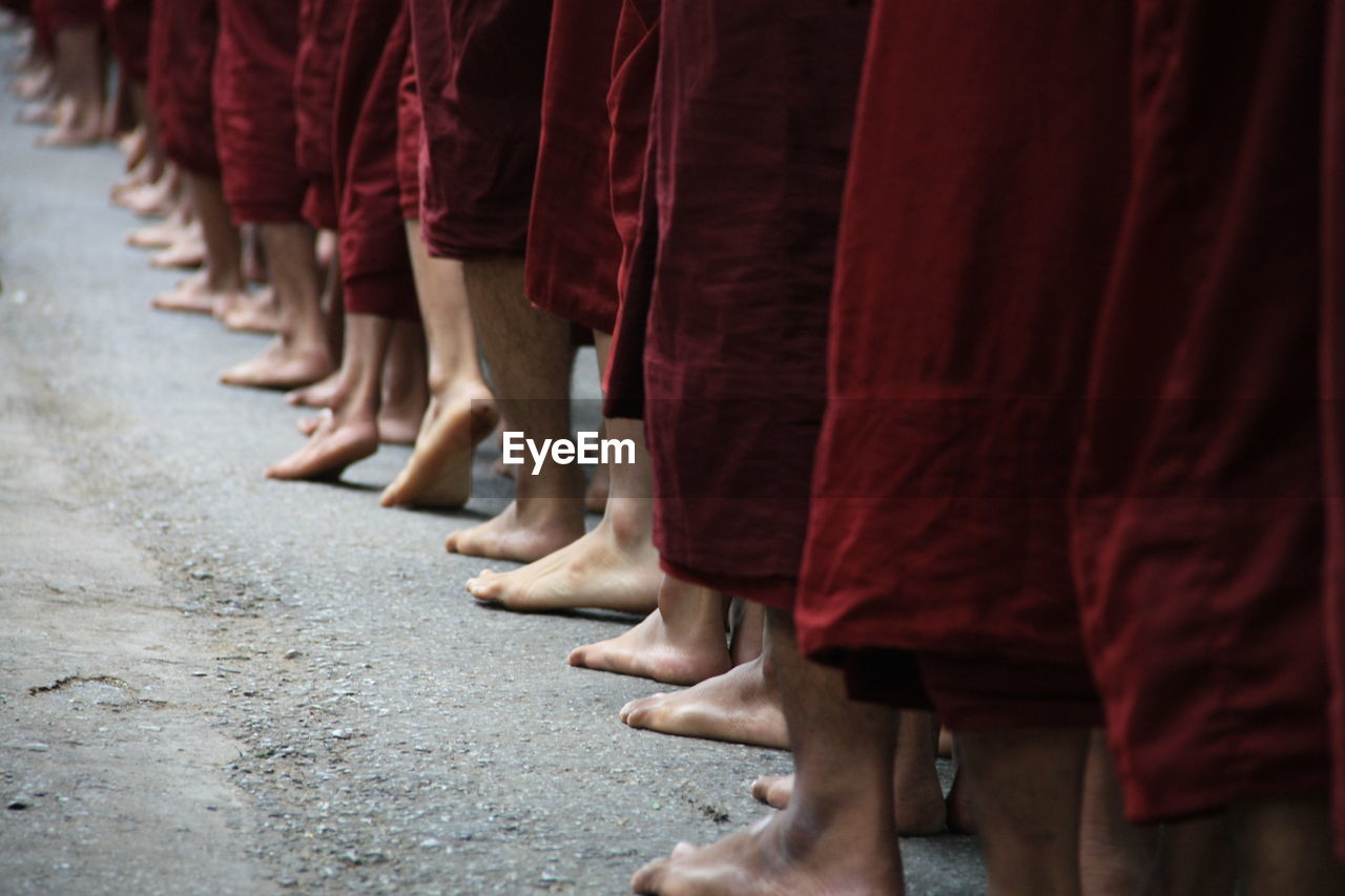 Low section of monks standing on road