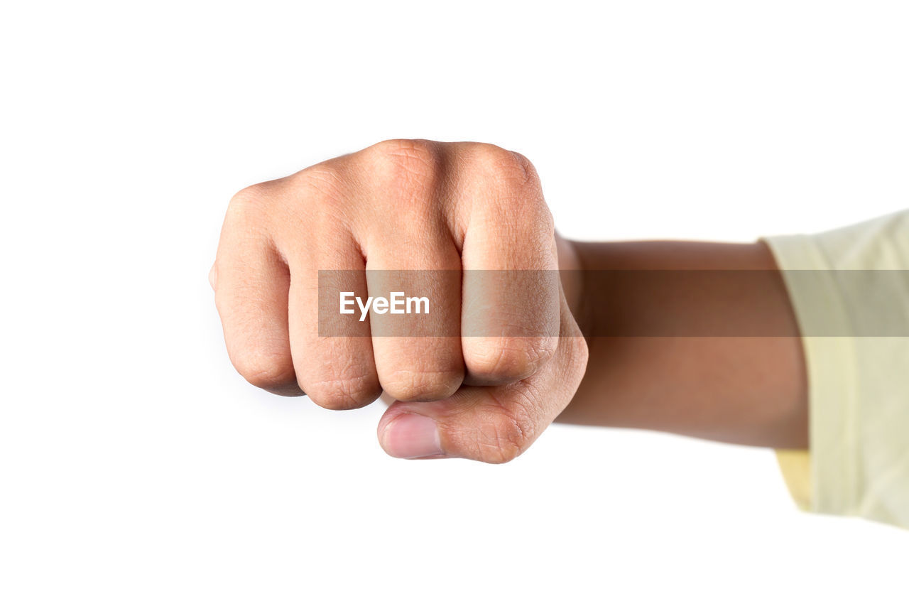 Cropped hand of person showing fist against white background