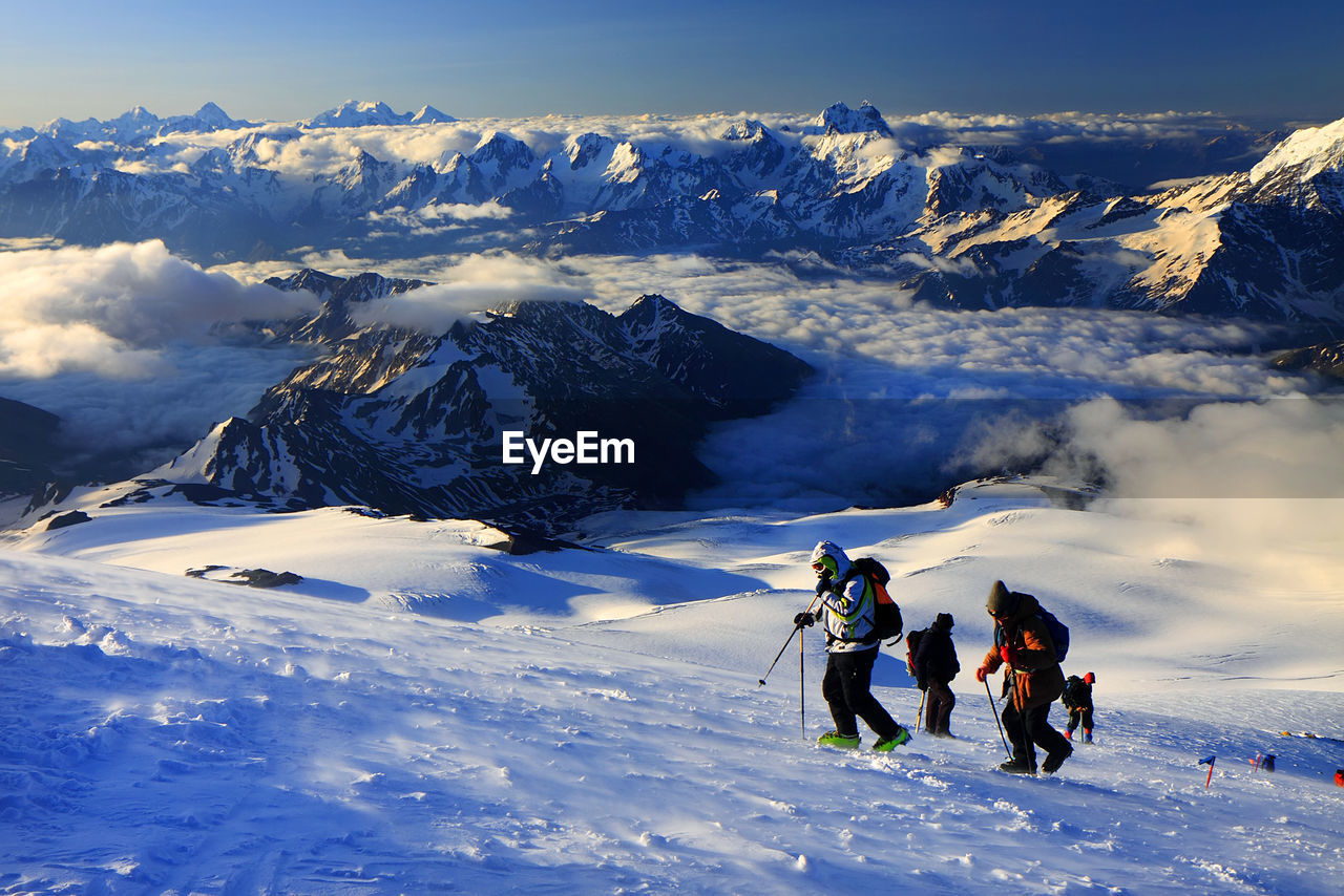 Skiers walking on snowcapped landscape