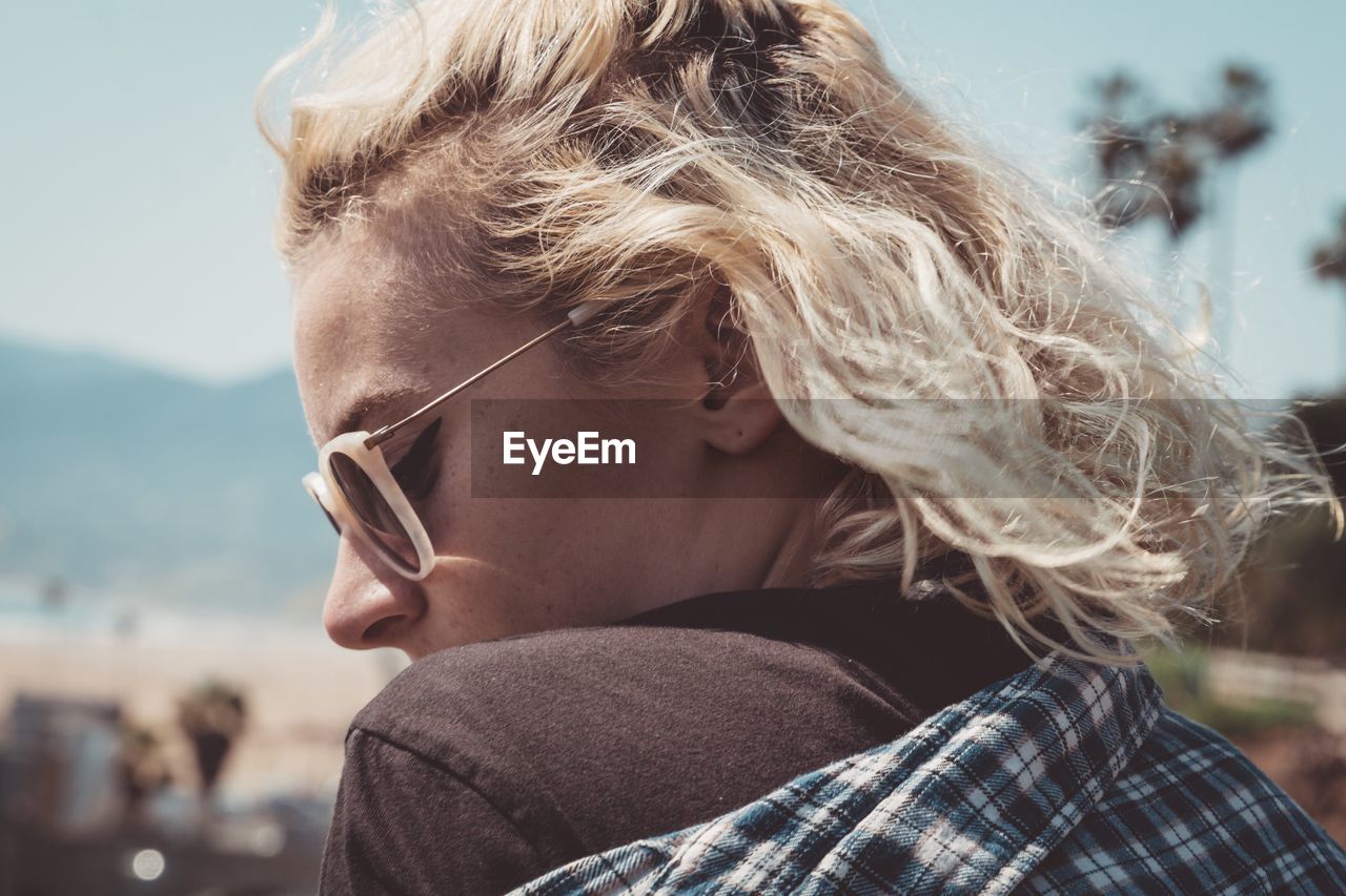 Close-up of woman wearing sunglasses against sky