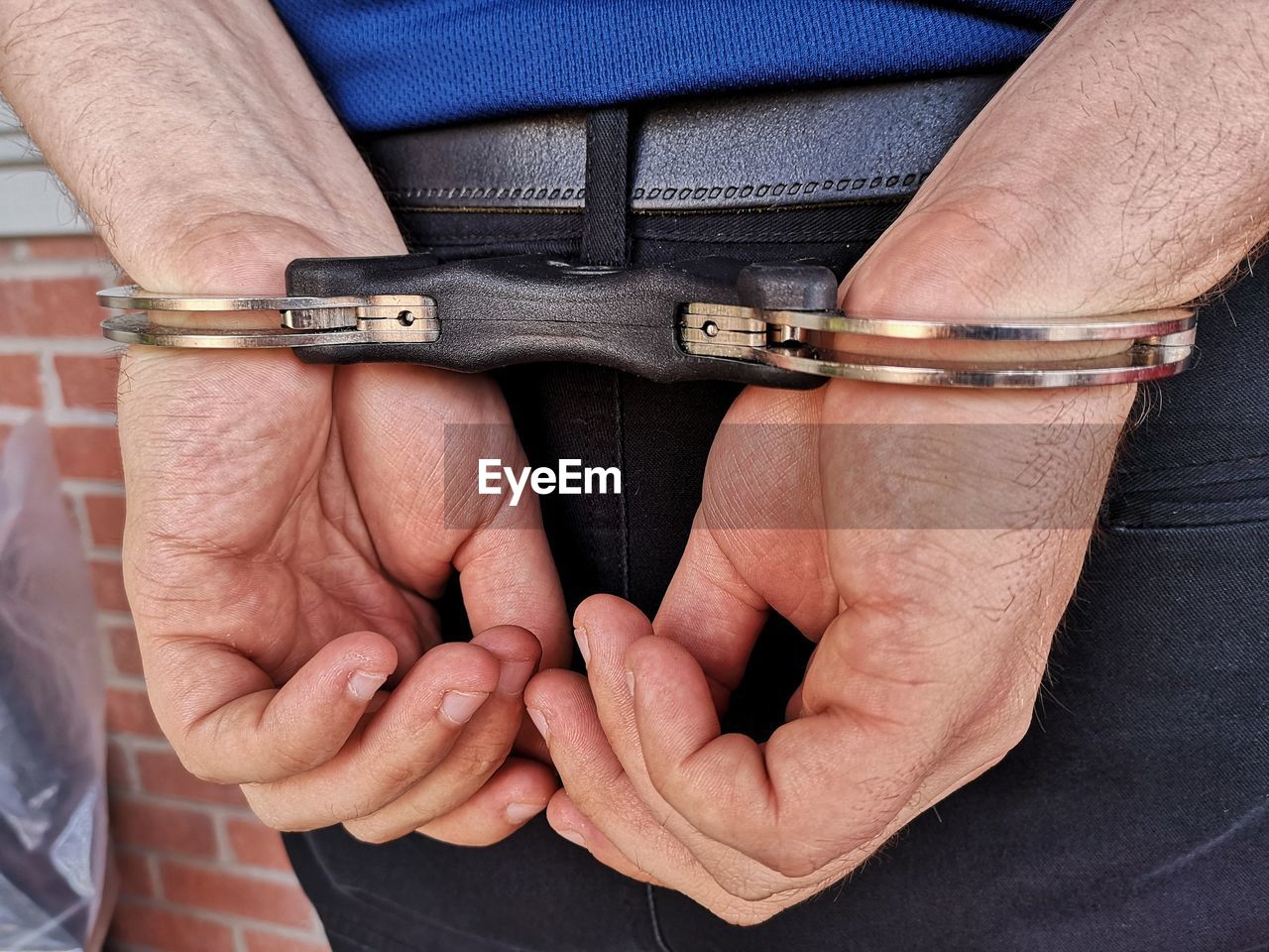 Midsection rear view of criminal wearing handcuffs