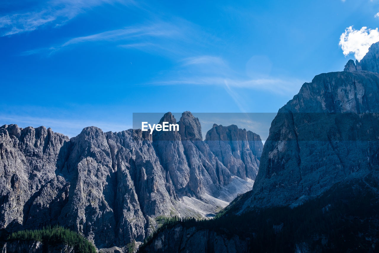 Panoramic view of mountains against blue sky