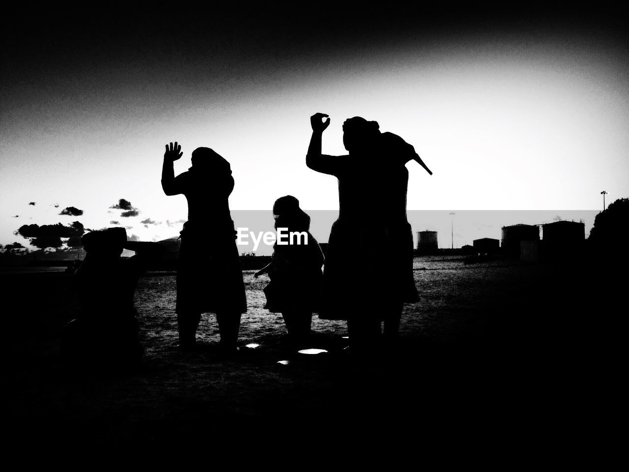 Silhouette family on field against sky
