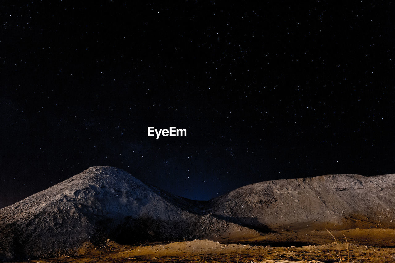 Scenic view of mountain against sky at night