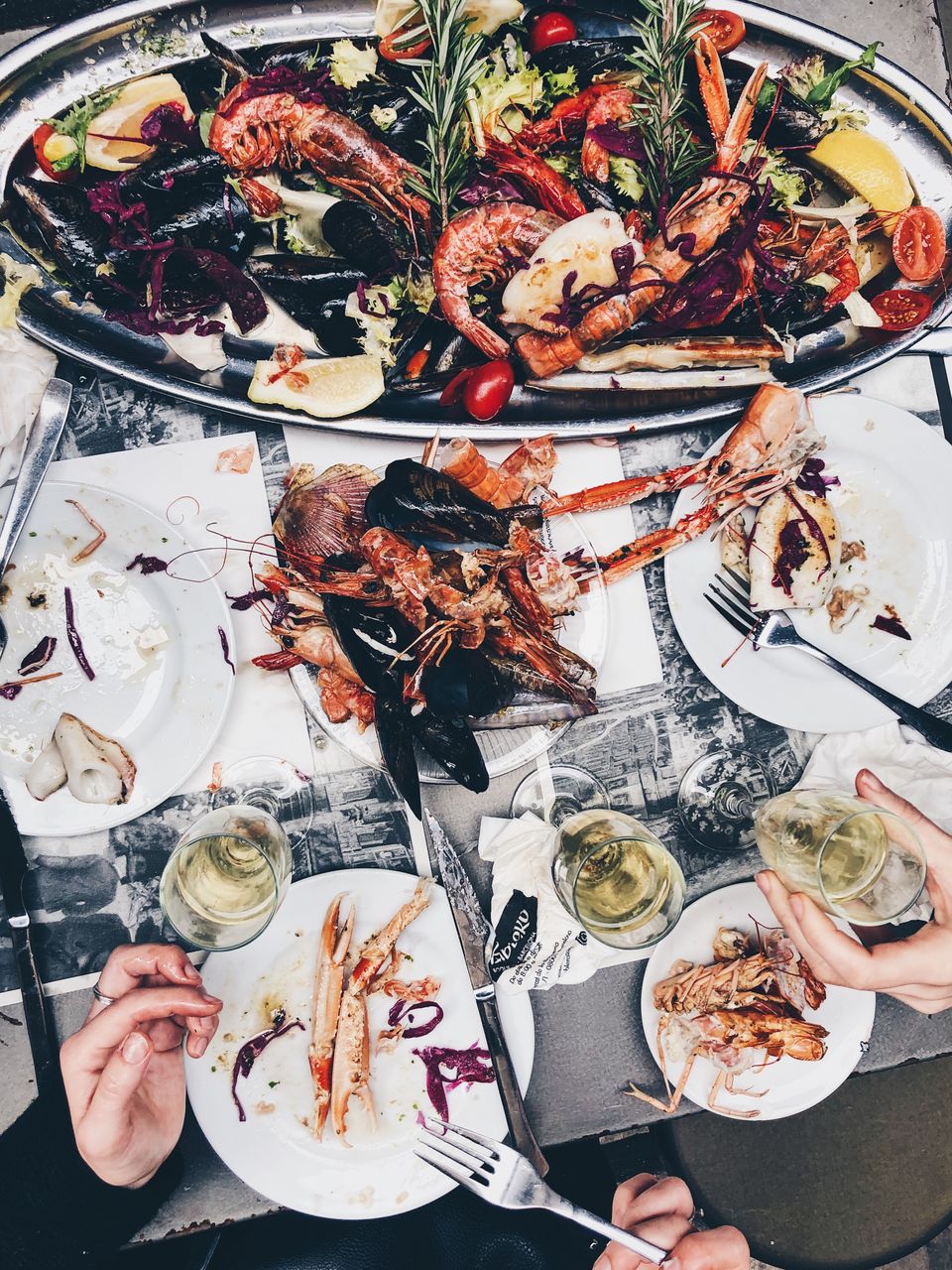Close-up of people eating seafood served in plate