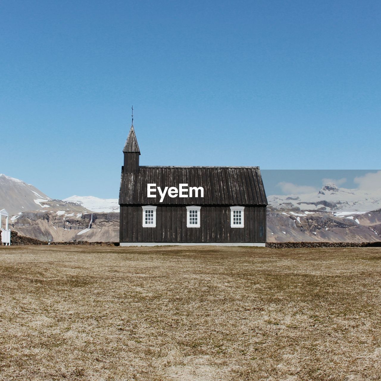 OLD BUILDING ON FIELD AGAINST SKY