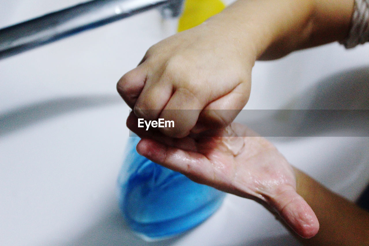Close-up of boy washing hands in sink