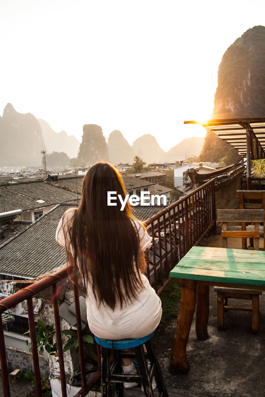 Yangshuo, china mountainous landscape exotic asian sunset watching sunset on the roof of the house.
