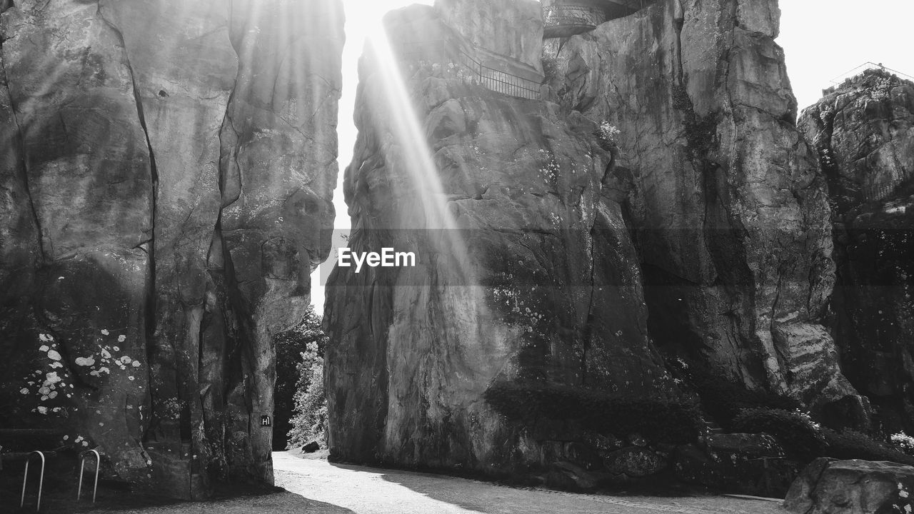 Low angle view of sunlight streaming through rock formations
