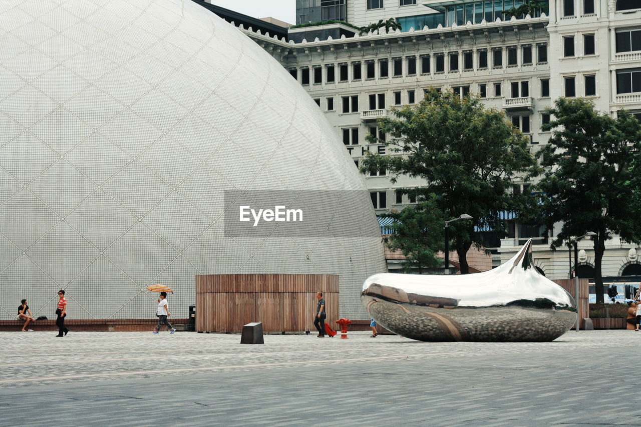 Modern building of sphere shape with sculpture of drop on town square