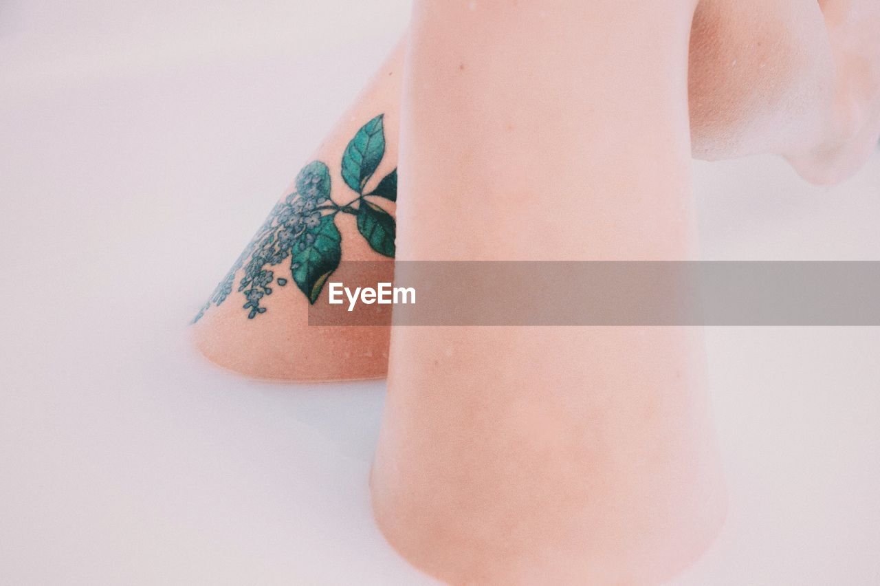 Cropped image of woman with tattoo on leg bathing in soap sud