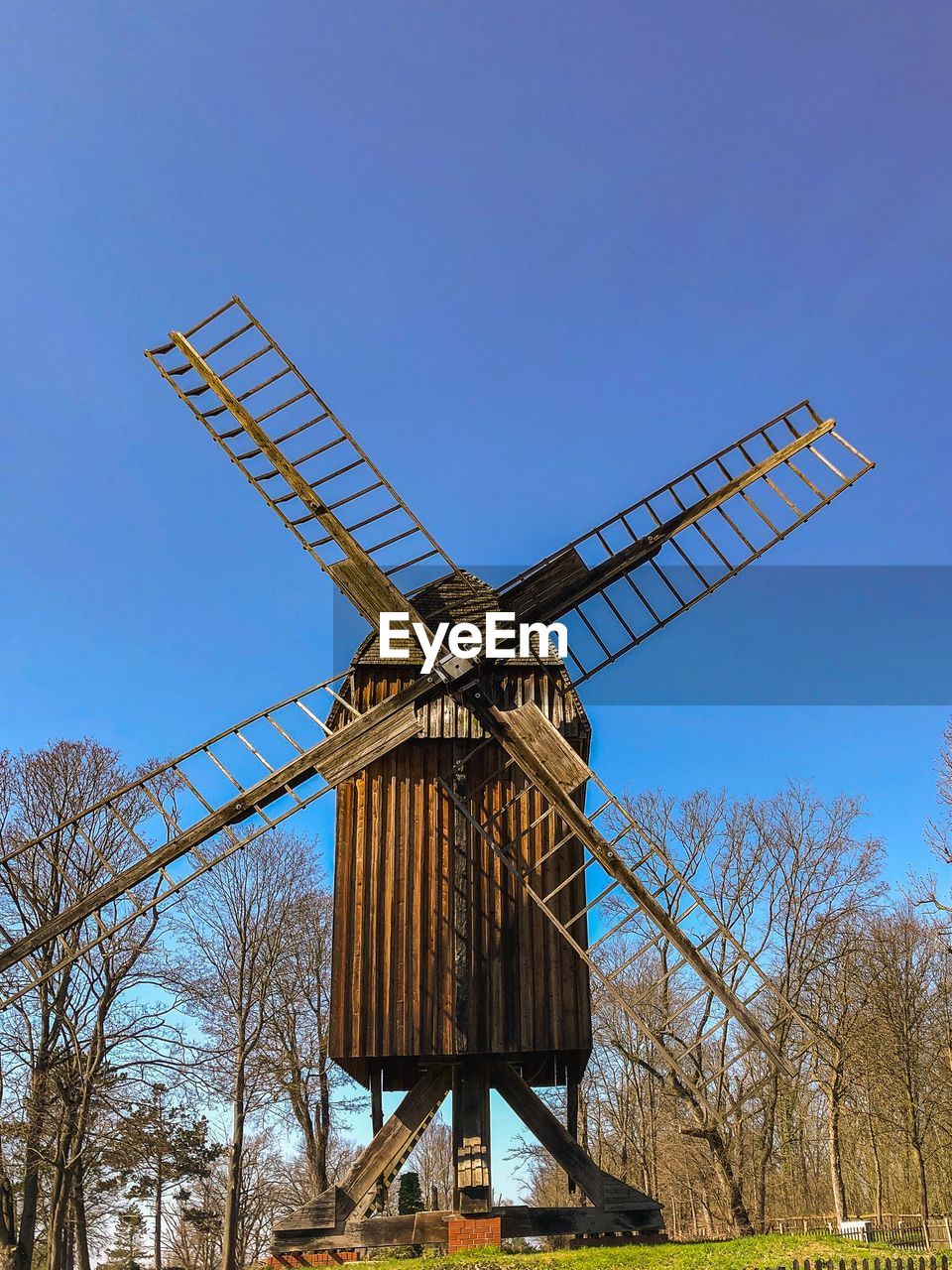 LOW ANGLE VIEW OF TRADITIONAL WINDMILL AGAINST BLUE SKY
