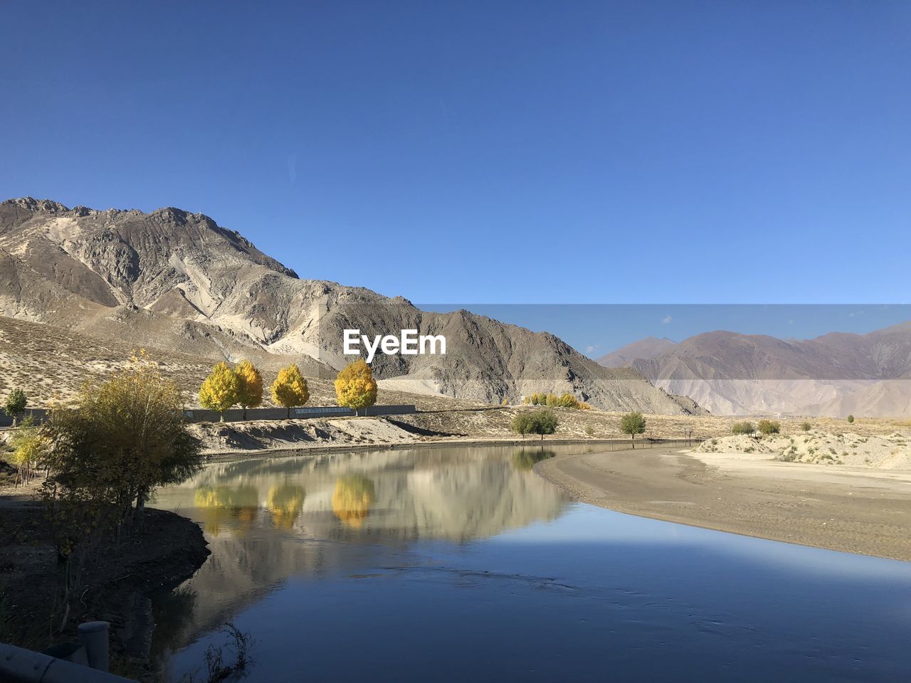 SCENIC VIEW OF LAKE BY MOUNTAINS AGAINST CLEAR BLUE SKY