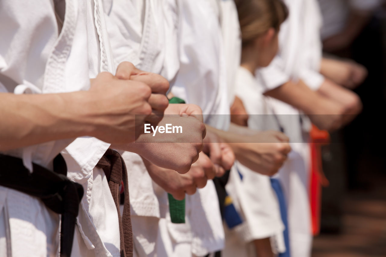 Midsection of people performing karate