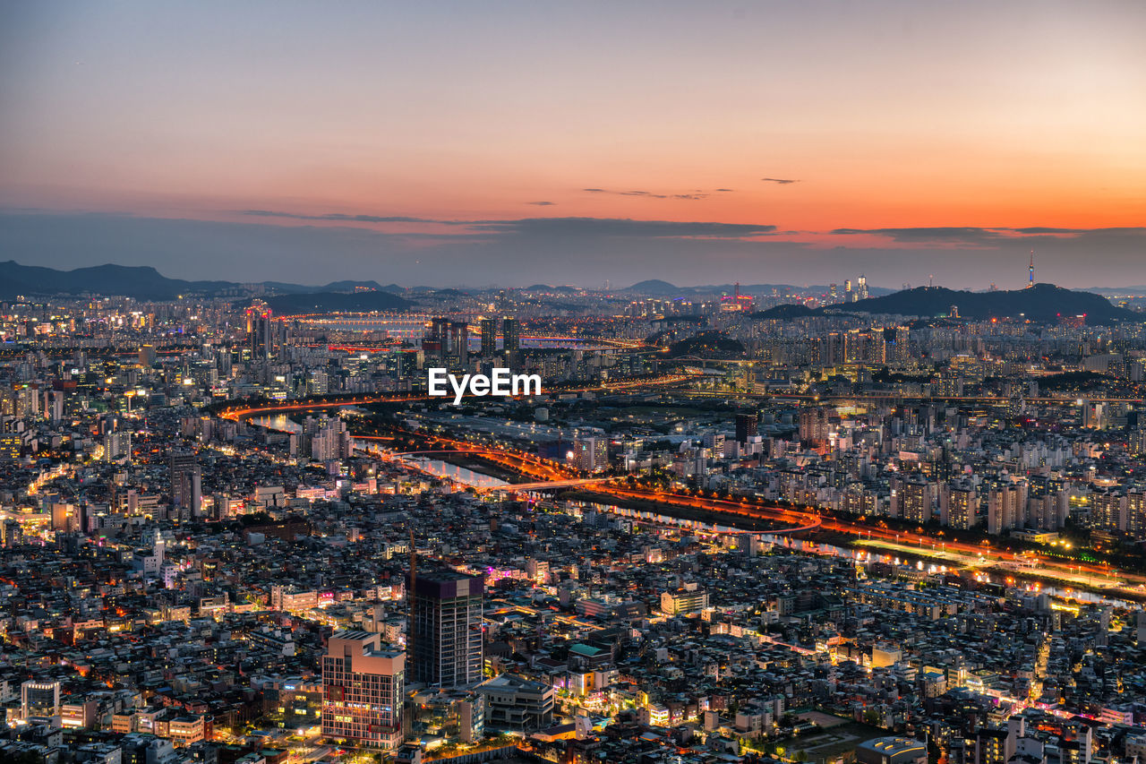High angle view of illuminated cityscape sky during sunset