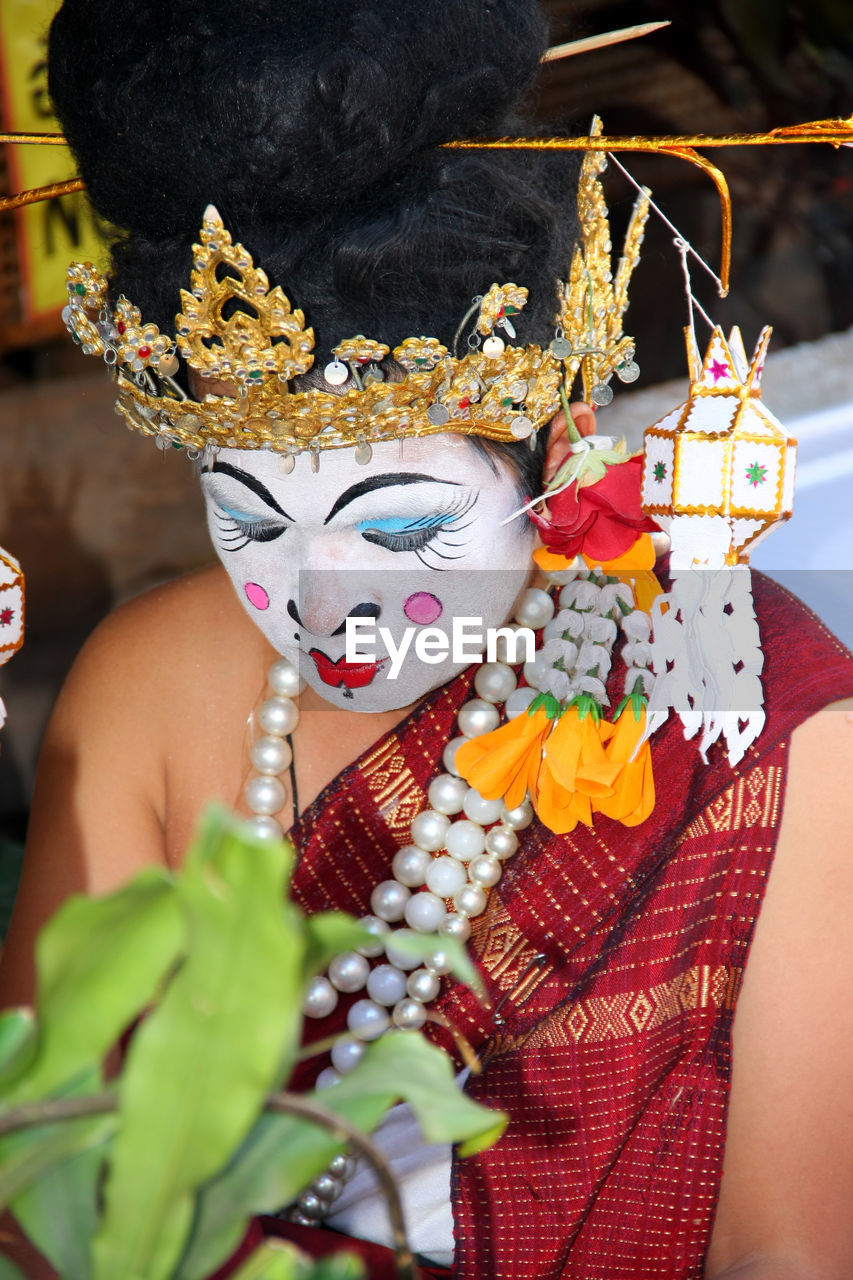 Man with painted face sitting during traditional ceremony