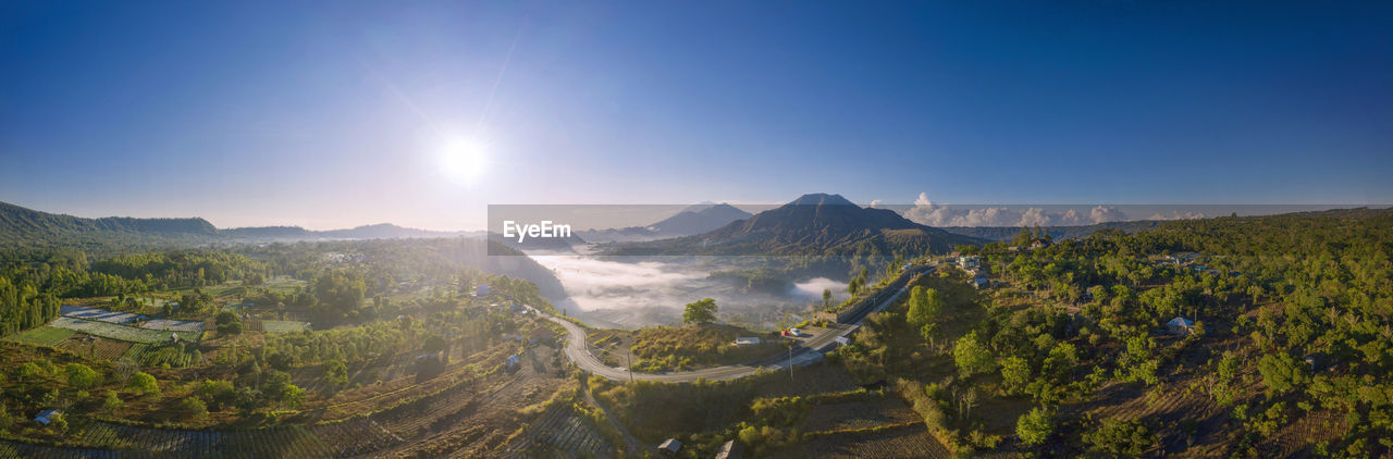 PANORAMIC VIEW OF MOUNTAINS AGAINST BRIGHT SUN