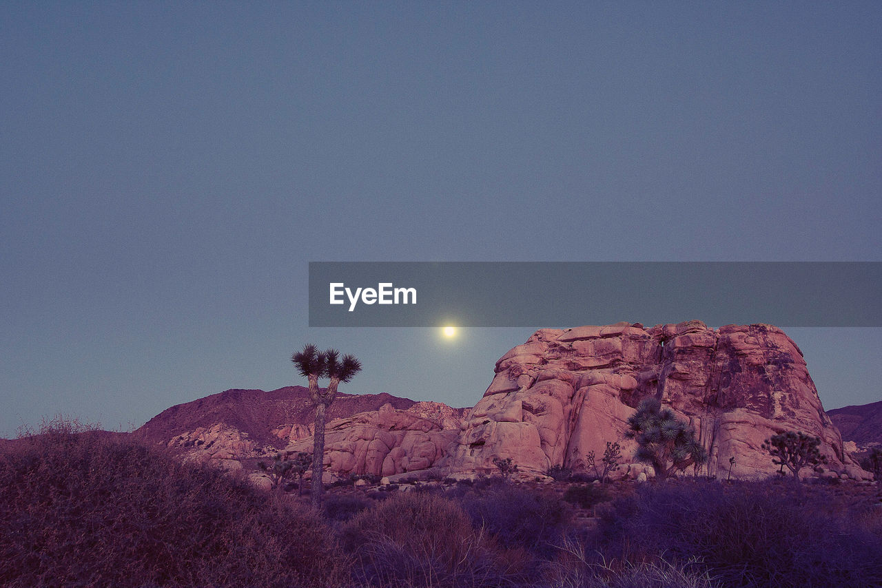 LOW ANGLE VIEW OF ROCKS AGAINST CLEAR SKY