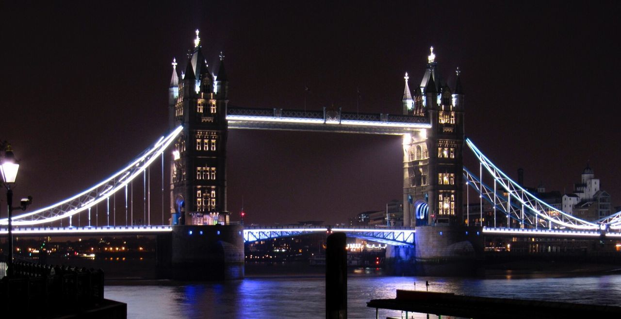 Low angle view of illuminated london bridge over river against sky