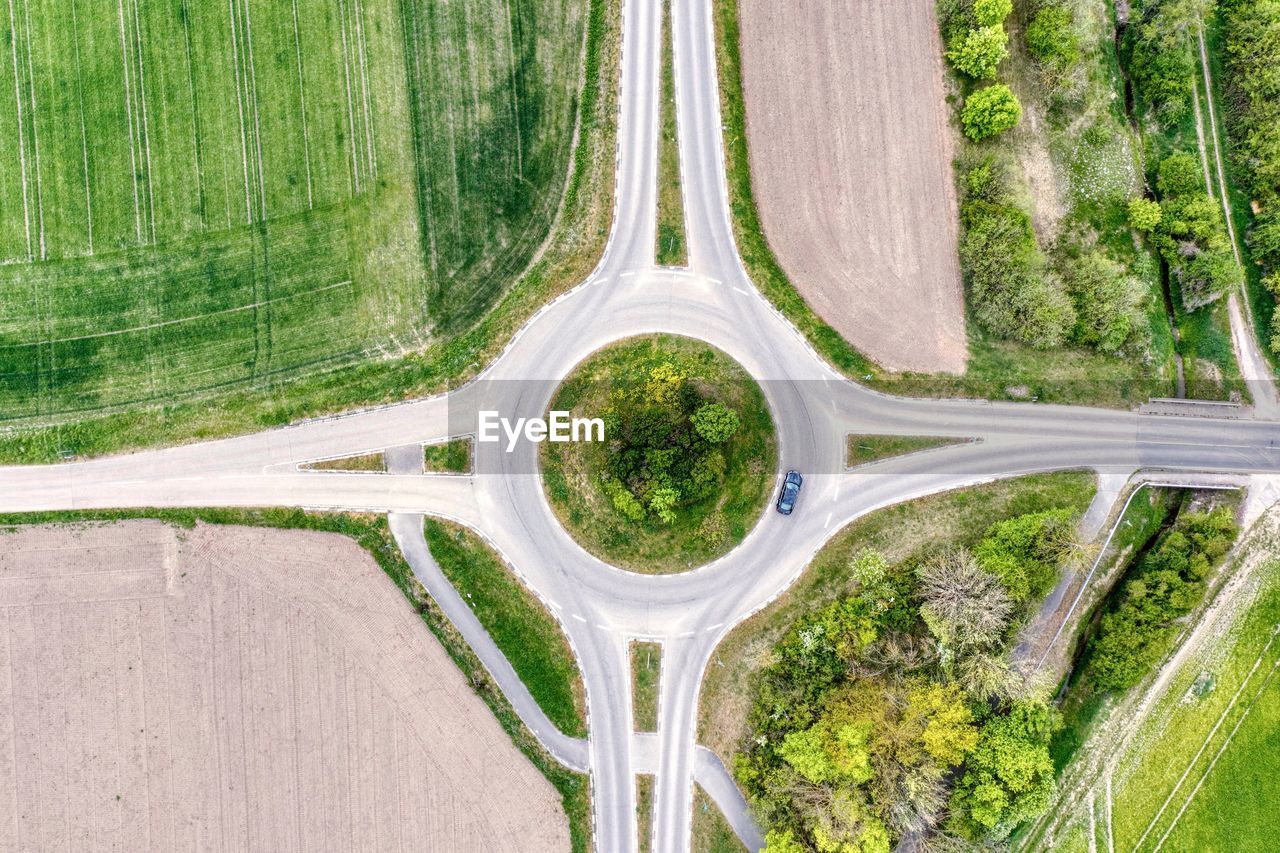 HIGH ANGLE VIEW OF ROAD AMIDST TREES AND PLANTS