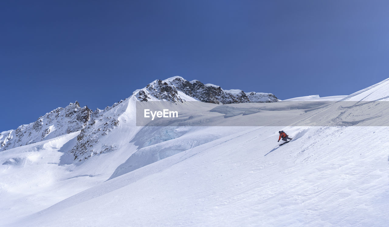 Person skiing on snowcapped mountain against sky