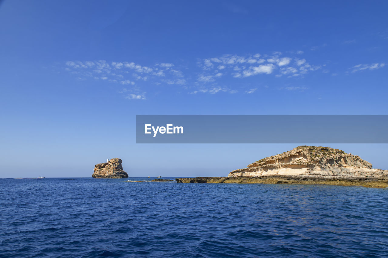 SCENIC VIEW OF ROCKS IN SEA AGAINST BLUE SKY