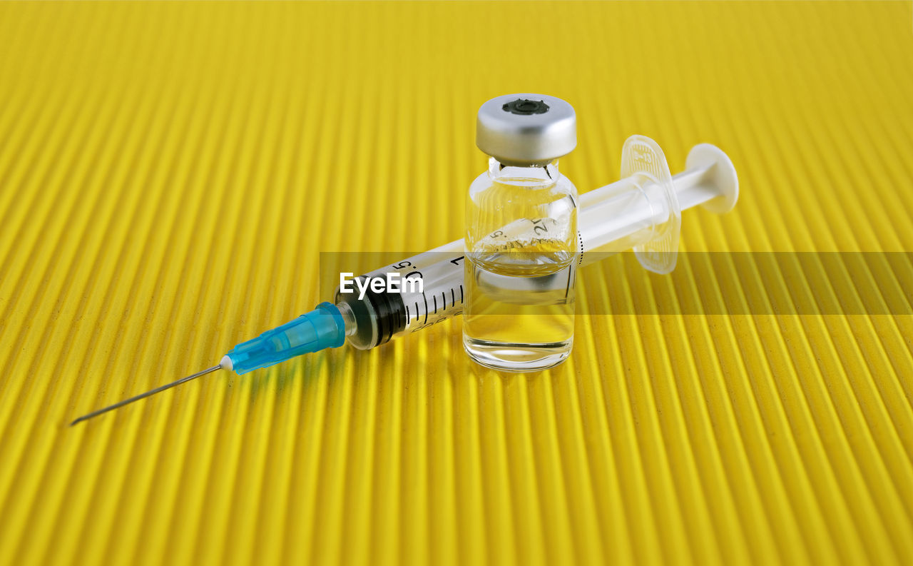 Close-up of syringe with vial on table