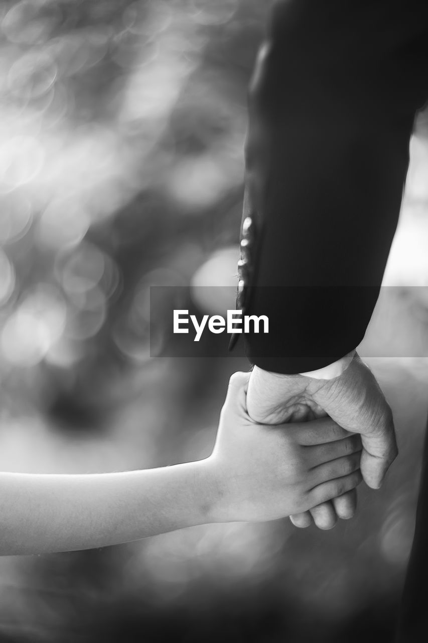 Cropped hand of child holding father hand