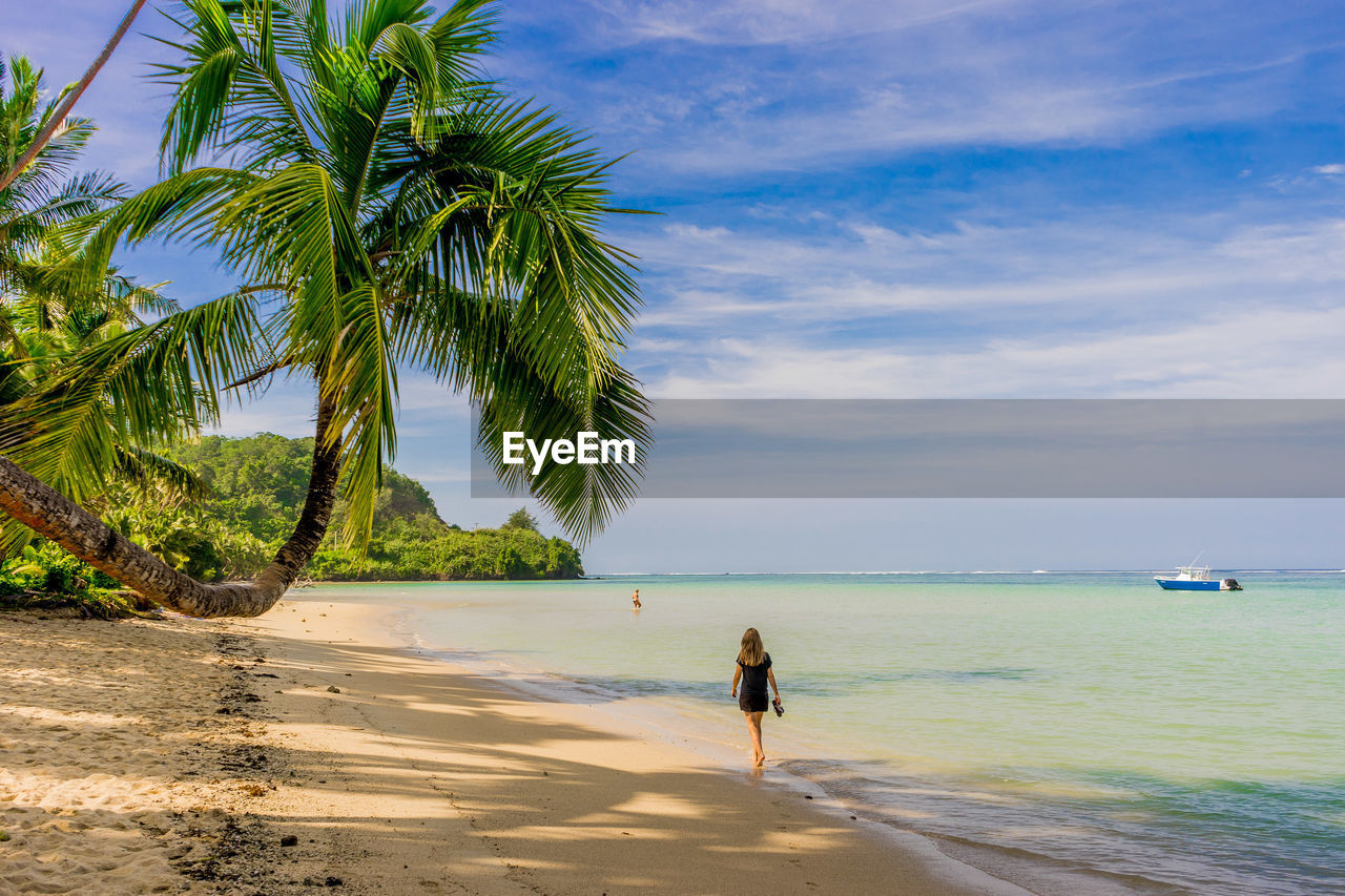 Rear view of woman walking on beach