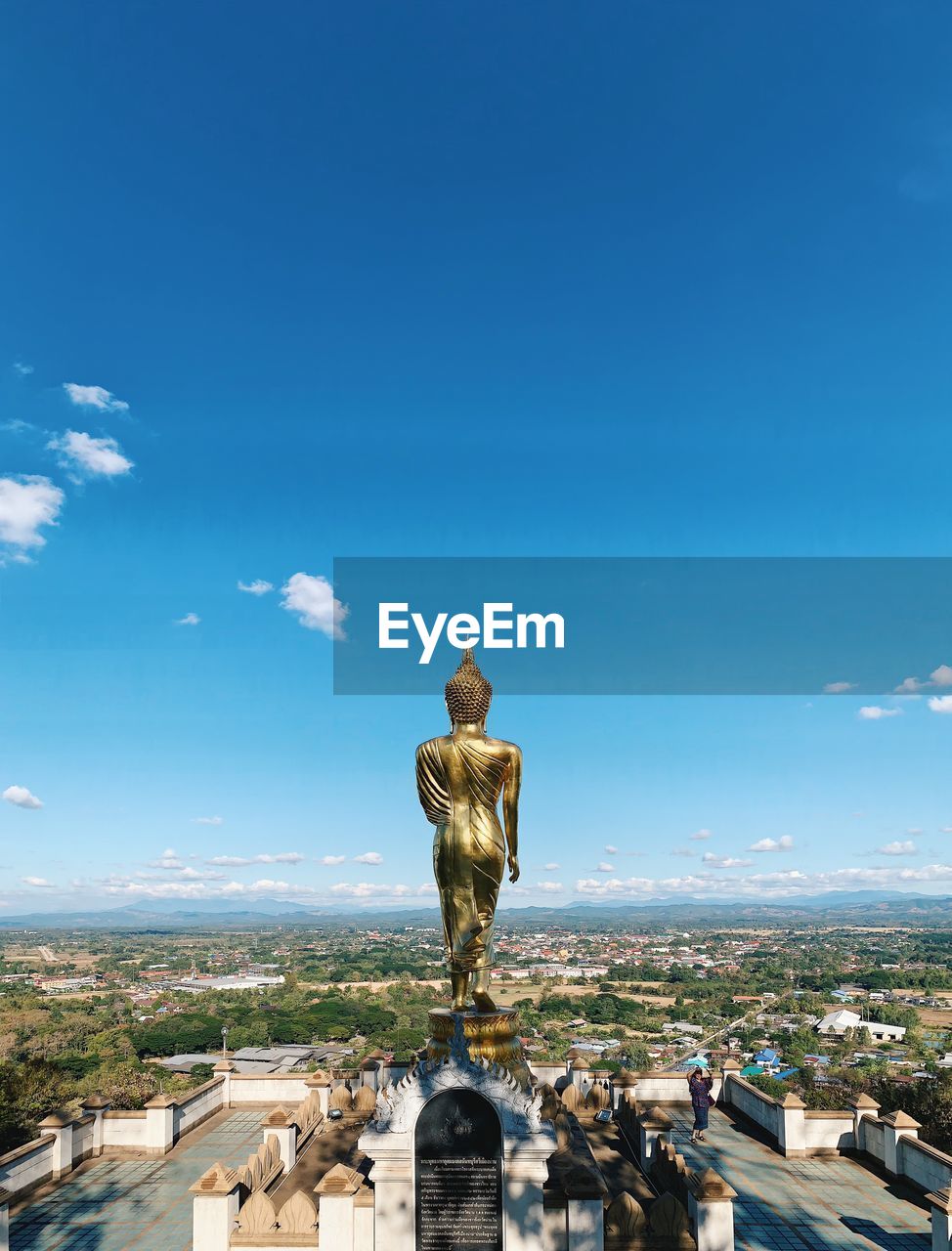 STATUE AGAINST BLUE SKY AND BUILDINGS IN CITY AGAINST CLEAR WEATHER