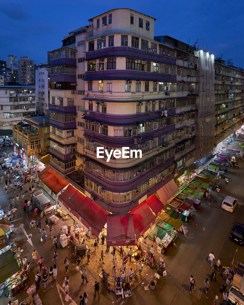 High angle view of people on street by buildings in city at night