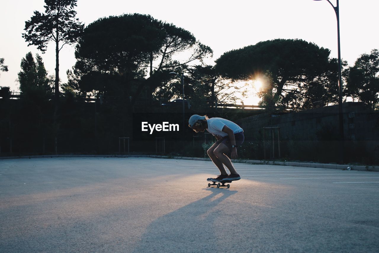 Full length of man skateboarding at playground during sunset
