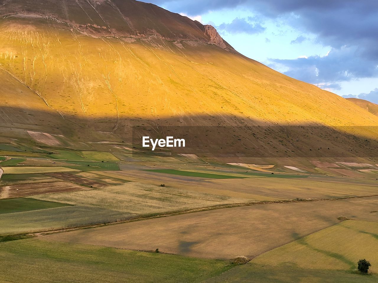 landscape, environment, hill, grassland, land, scenics - nature, plain, nature, beauty in nature, sky, field, prairie, cloud, rural scene, steppe, agriculture, plateau, grass, plant, no people, rural area, non-urban scene, tranquility, travel, travel destinations, outdoors, mountain range, tranquil scene, valley, sunlight, day, green, social issues, tourism, highland, lake, horizon, farm, semi-arid, idyllic, environmental conservation, yellow, meadow, multi colored, summer, morning, remote