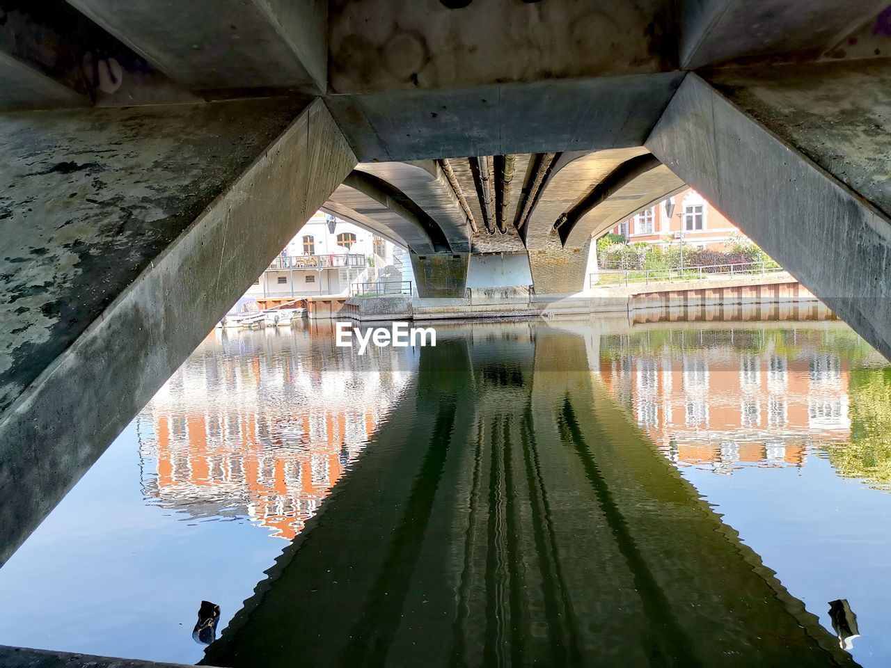 REFLECTION OF BRIDGE ON RIVER UNDER ARCH