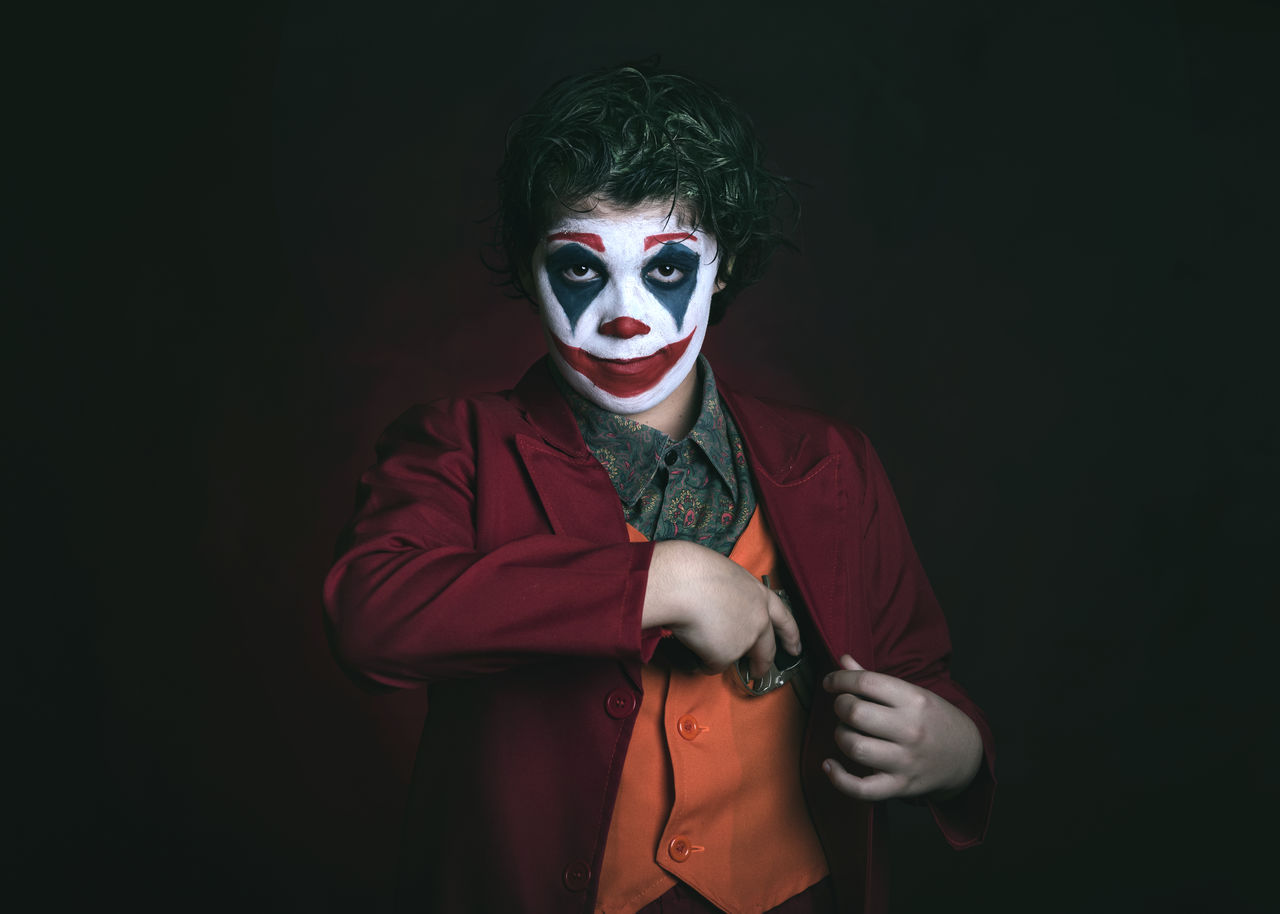 Portrait of boy wearing mask against black background
