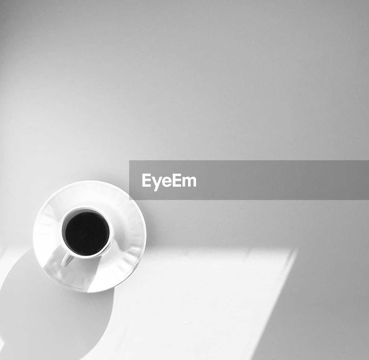 white, cup, coffee cup, mug, coffee, indoors, circle, drink, black, copy space, food and drink, table, refreshment, no people, lighting, black and white, toilet paper, still life, ceramic, paper, shadow, crockery, light, high angle view