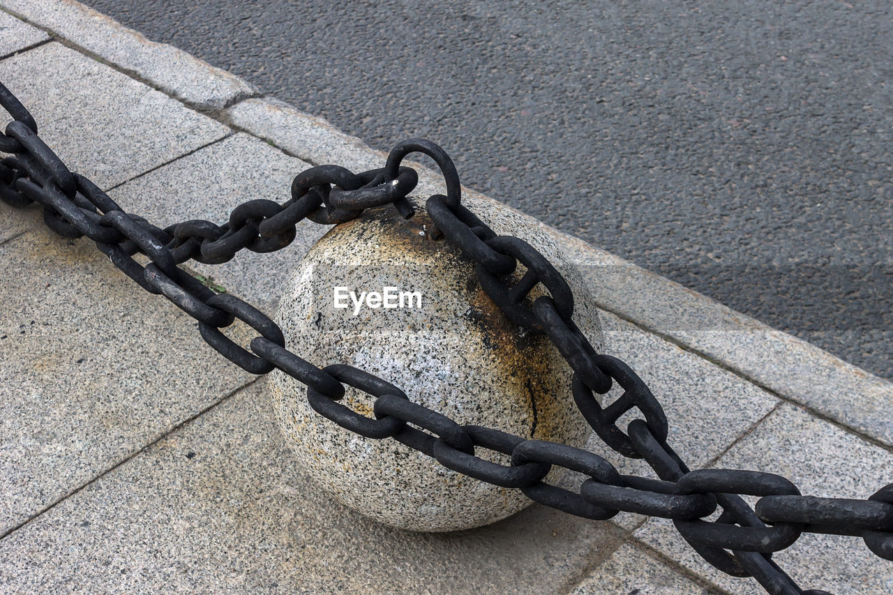 CLOSE-UP OF CHAIN ON METAL FENCE