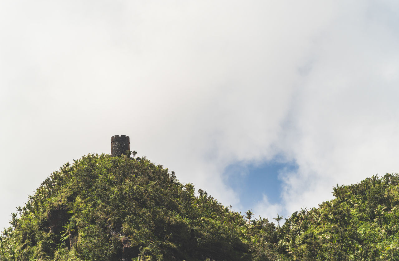 tree, sky, plant, hill, cloud, nature, architecture, environment, built structure, no people, forest, travel, land, outdoors, travel destinations, rural area, building exterior, building, low angle view, landscape, beauty in nature, tourism, history, fog, scenics - nature, the past, social issues, day, tower
