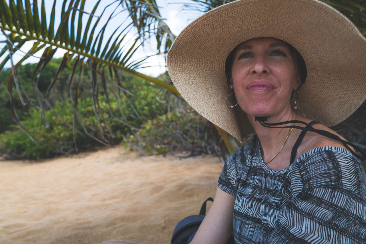 adult, hat, one person, smiling, portrait, women, clothing, happiness, nature, sombrero, sun hat, plant, emotion, leisure activity, lifestyles, trip, vacation, day, rural scene, tree, looking at camera, person, land, female, front view, holiday, outdoors, enjoyment, landscape, travel, straw hat, cheerful, mature adult, casual clothing, human face, summer, relaxation, palm tree, agriculture, headshot, senior adult, spring, travel destinations