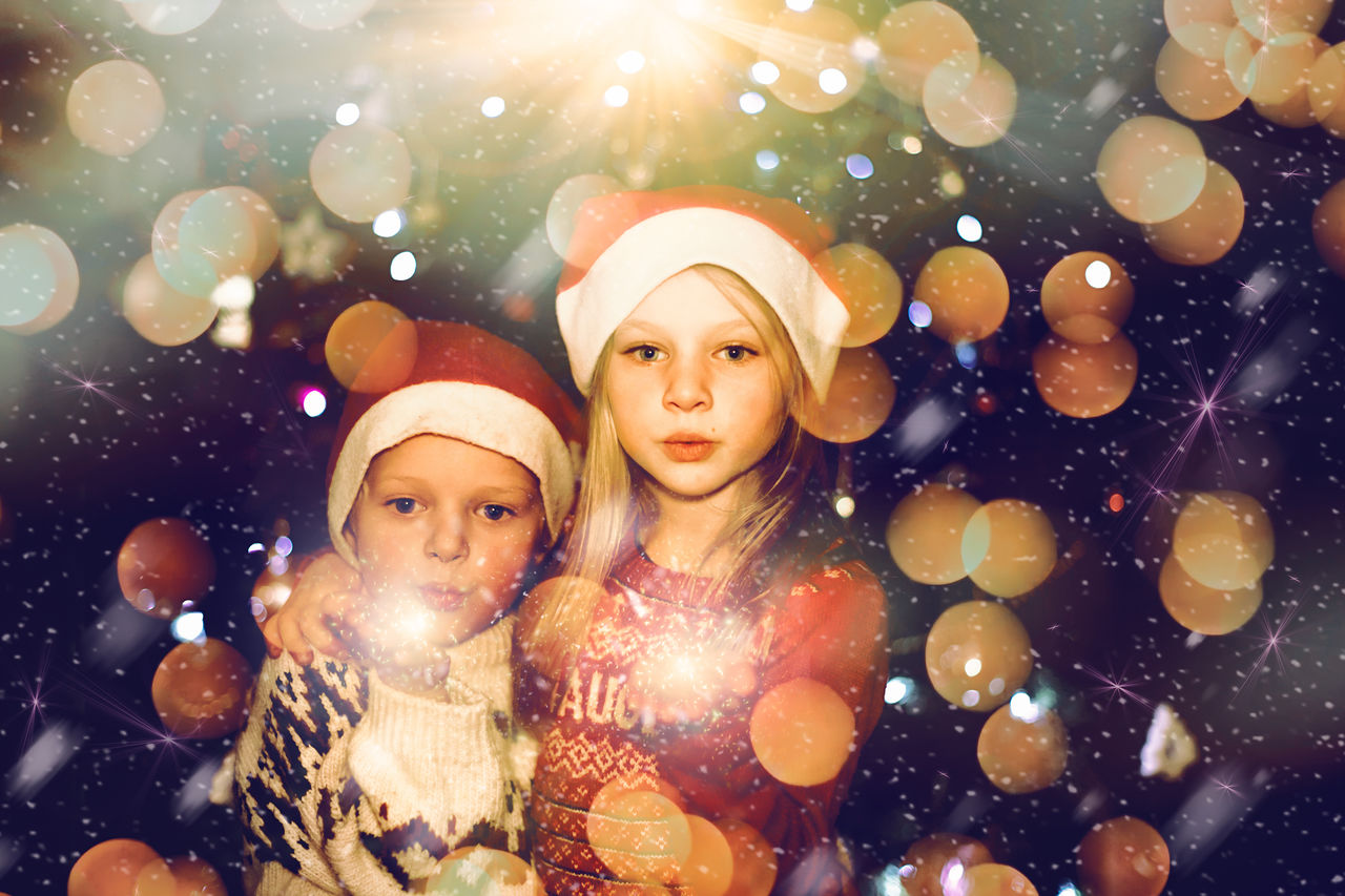 Kids celebrating christmas holiday with sparkler and santa hat