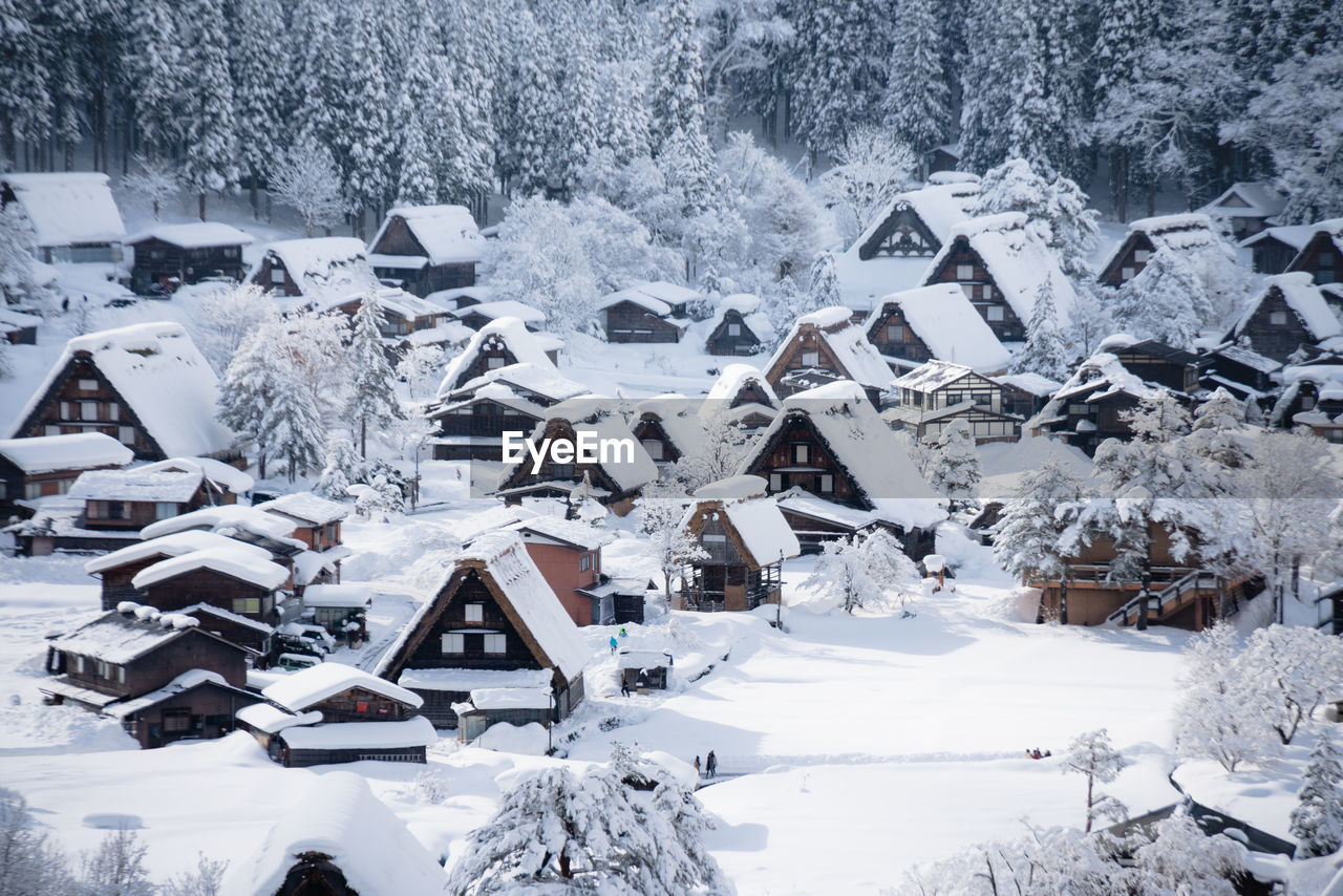 Snow covered houses by buildings