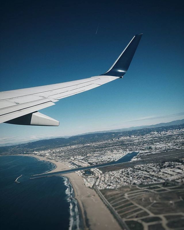 CROPPED IMAGE OF AIRPLANE WING OVER SEA