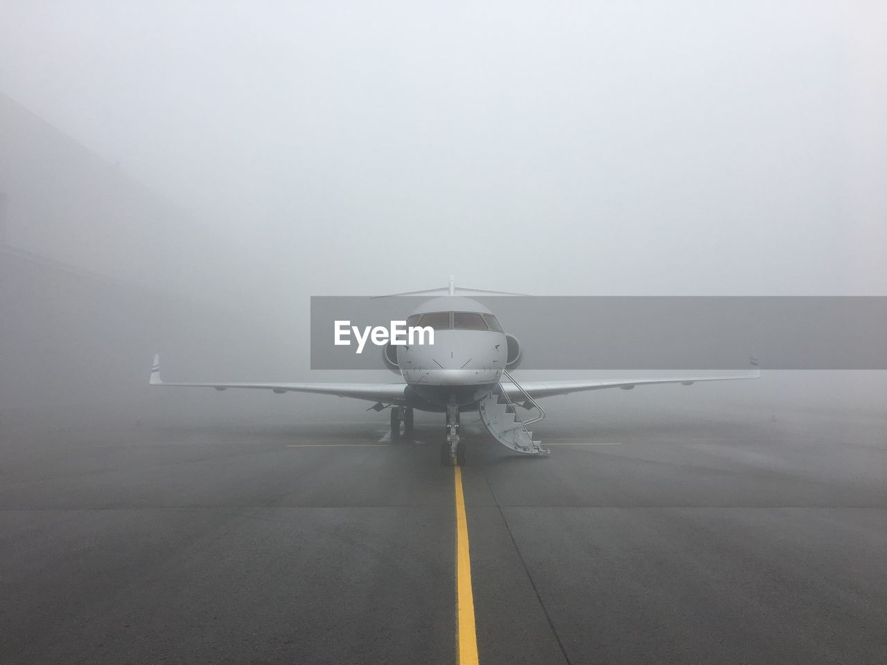 Airplane at runway during foggy weather