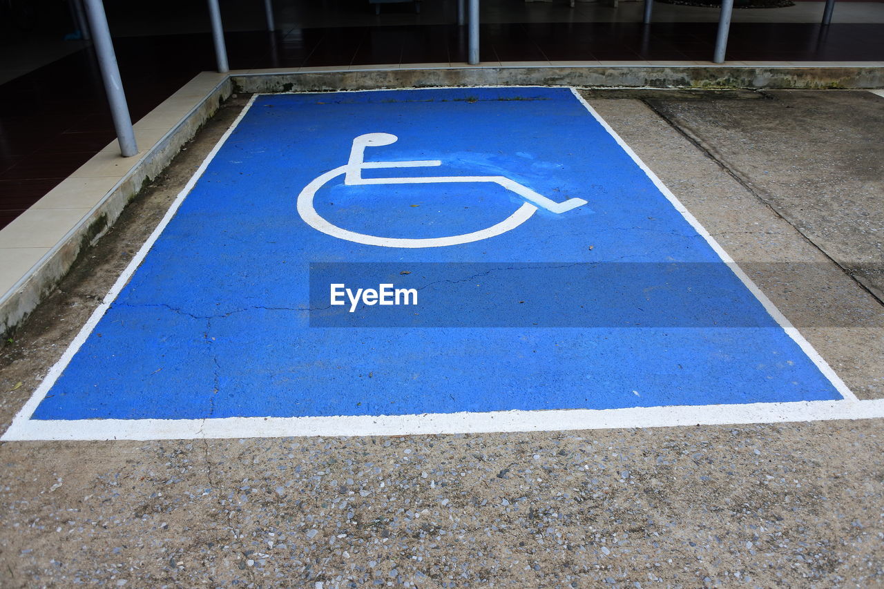 High angle view of wheelchair access sign on parking lot