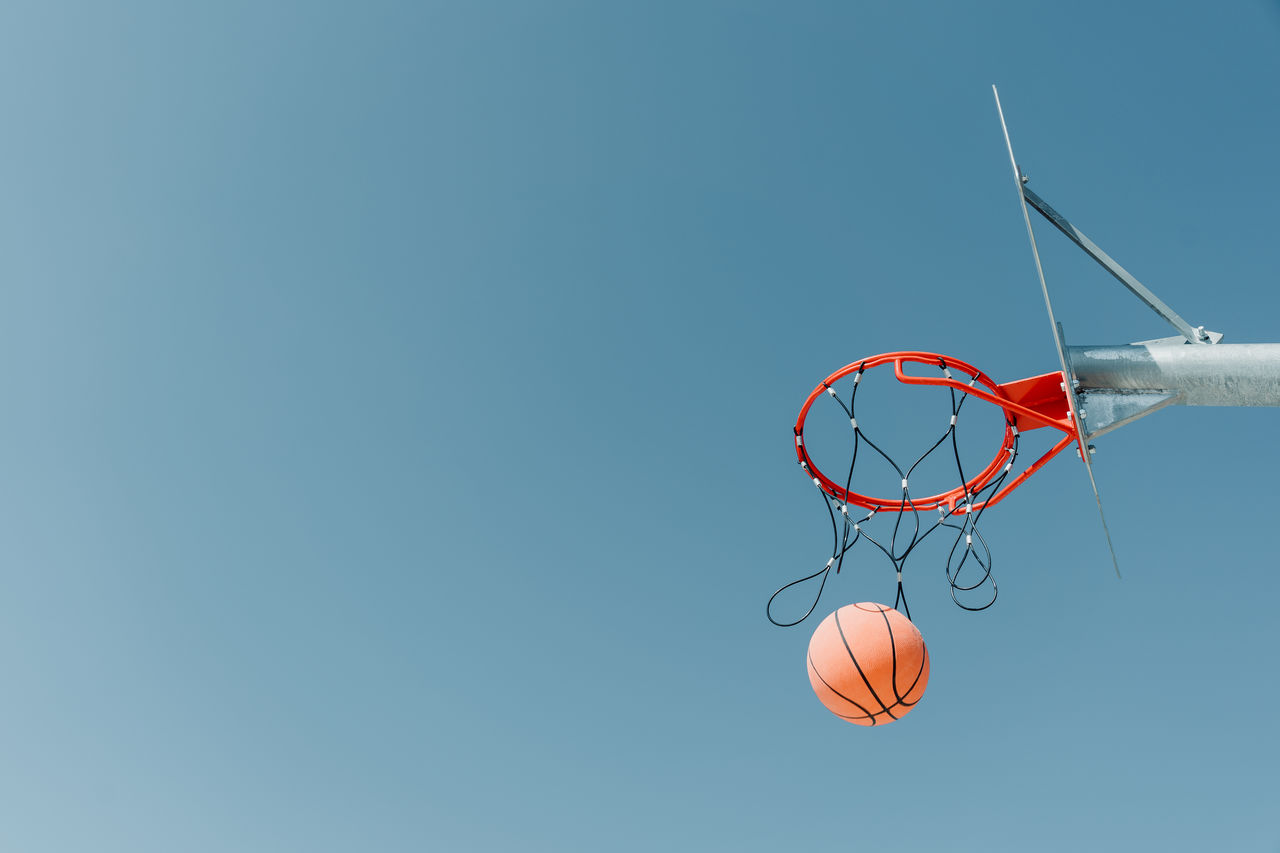 LOW ANGLE VIEW OF BASKETBALL HOOP AGAINST CLEAR SKY