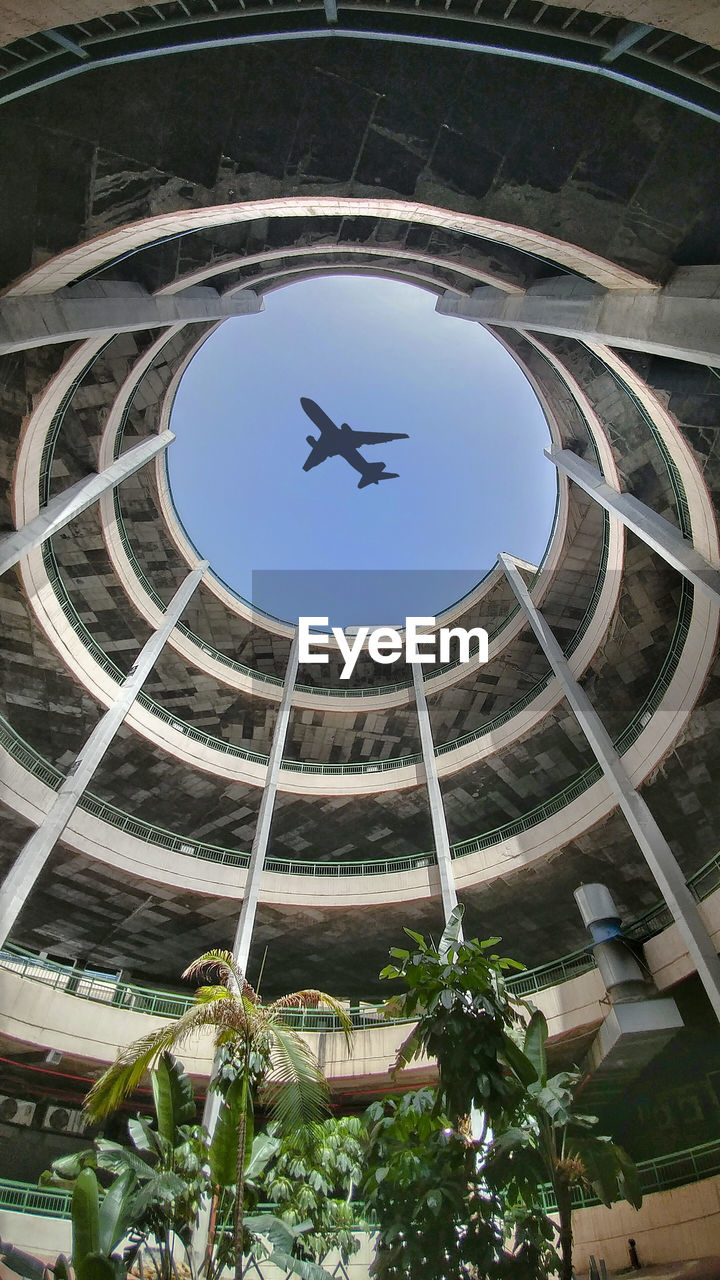 LOW ANGLE VIEW OF BIRDS FLYING OVER BUILT STRUCTURE