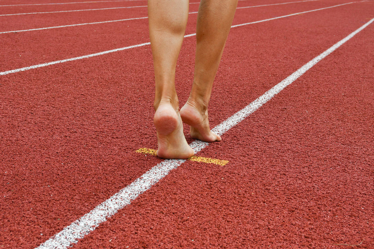 Low section of woman walking on sports track