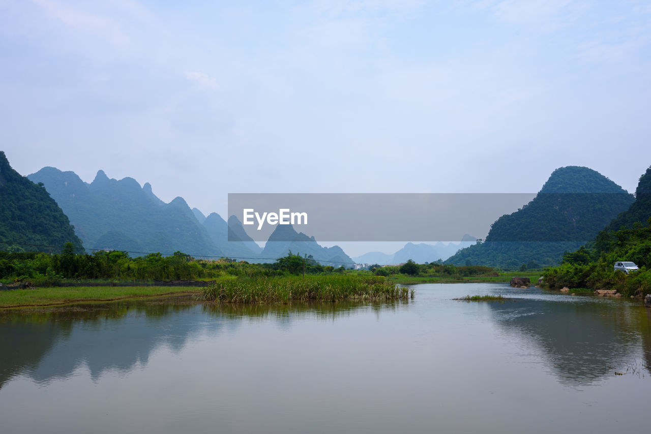 Scenic view of lake and mountains against sky