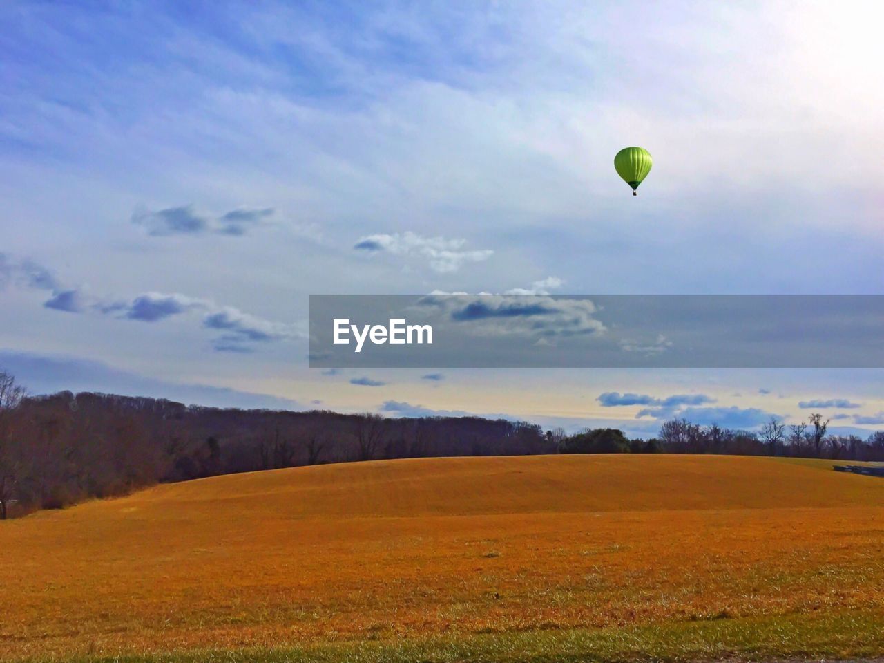 Low angle view of hot air balloon above landscape in sky